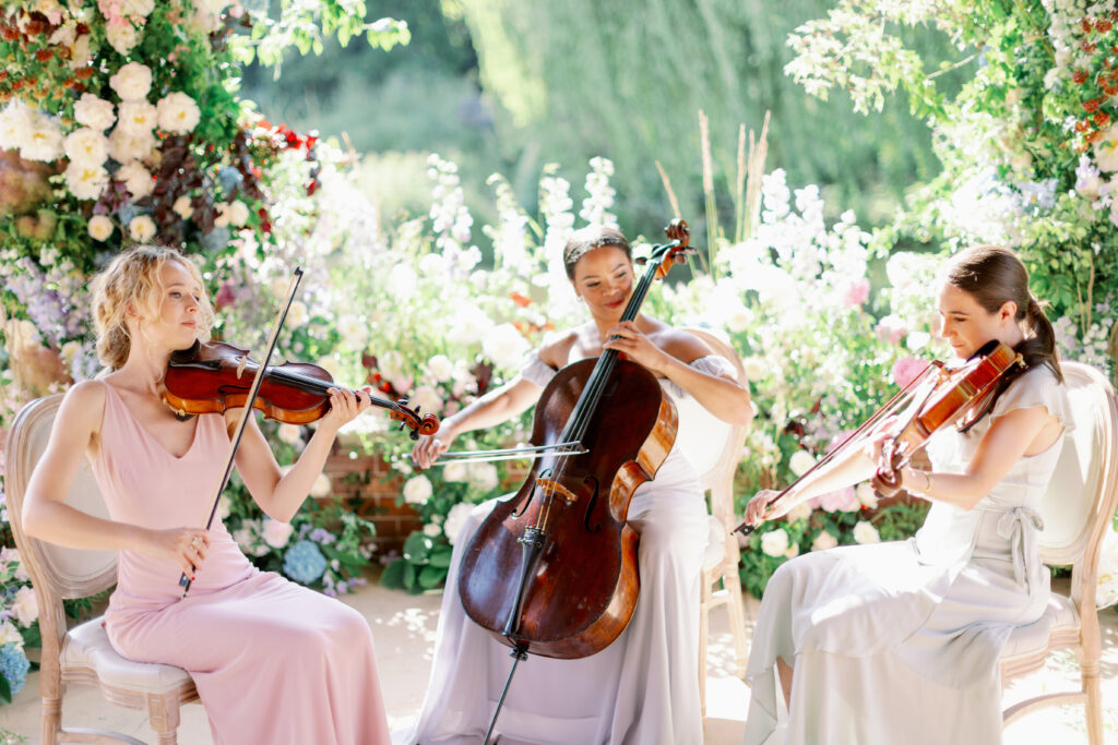 Elan Artists string trio wear selection of Nola London dresses in Blush Pink, Mist Blue and Sage Green.